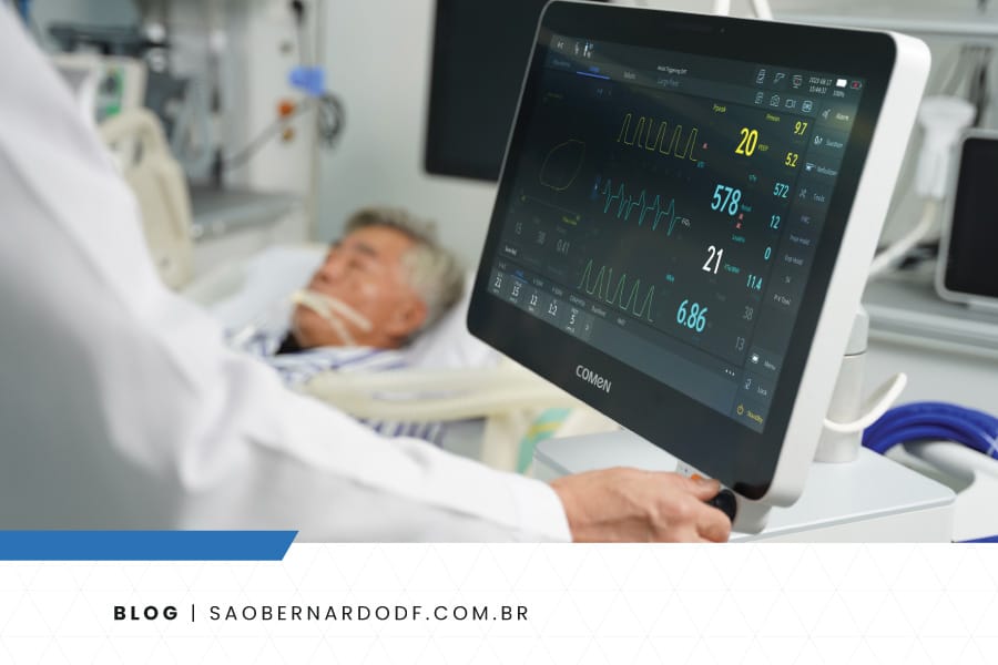 Profissional de saúde analisando monitor multiparâmetros com sinais vitais de paciente em UTI